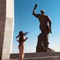 Student posing next to a statue